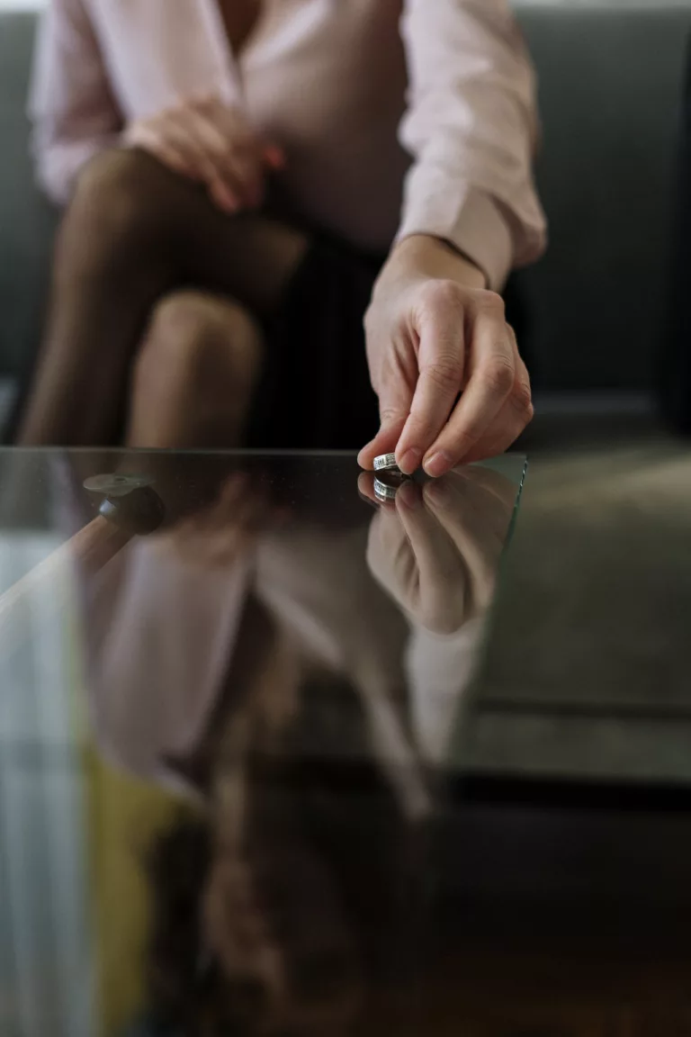 Person putting ring on table in an attorney's office. Therapy for Divorce in the United States can help divorced individuals in New York City, NYC, Washington, DC, Philadelphia, PA and beyond.